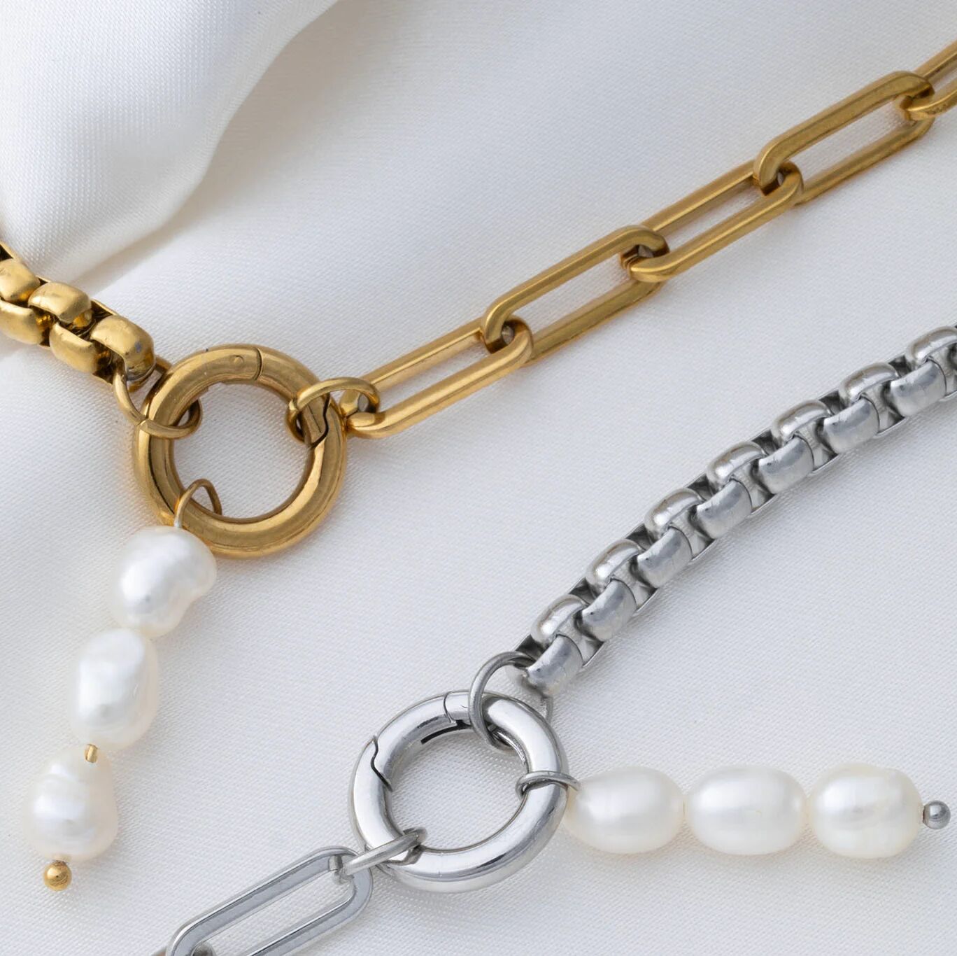 Gold and silver chain necklaces with pearls on a white background