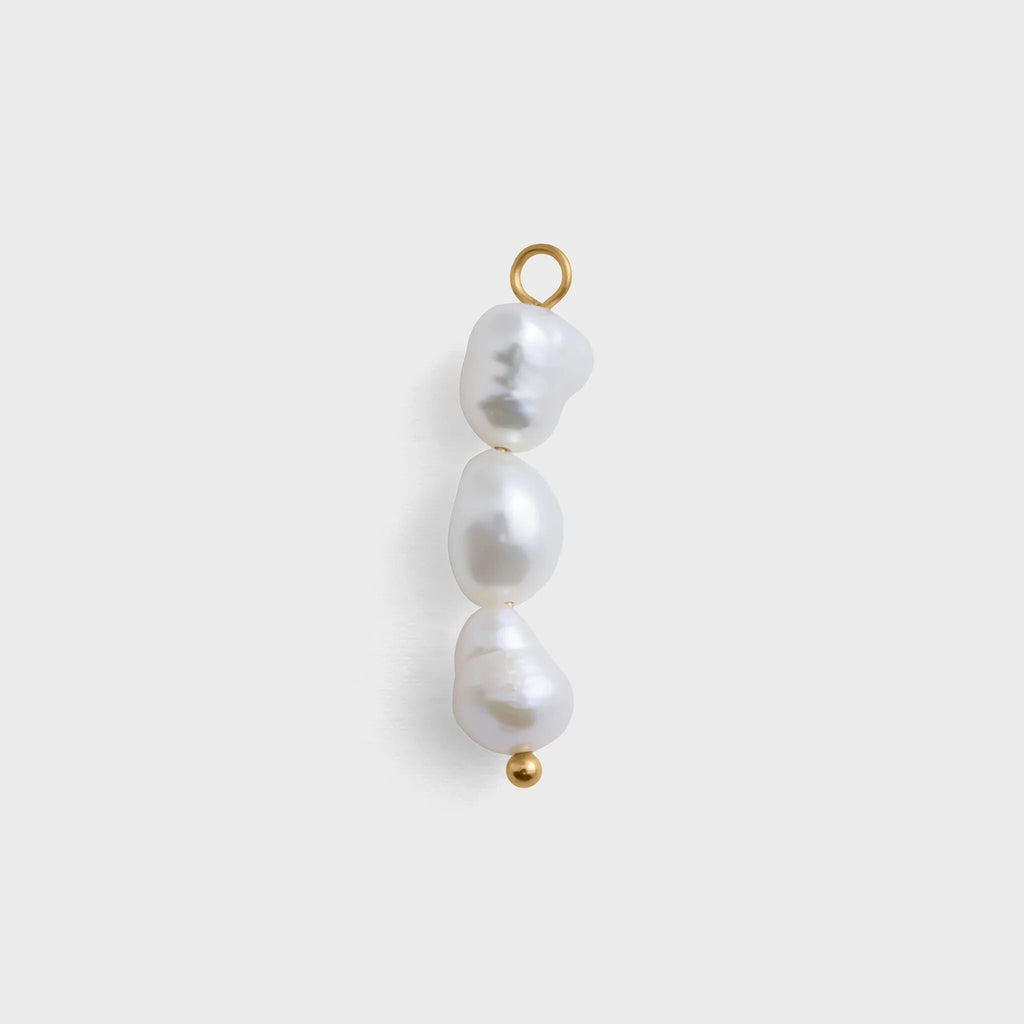 Three pearl beads with gold clasps on a white background