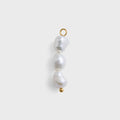Three pearl beads with gold clasps on a white background
