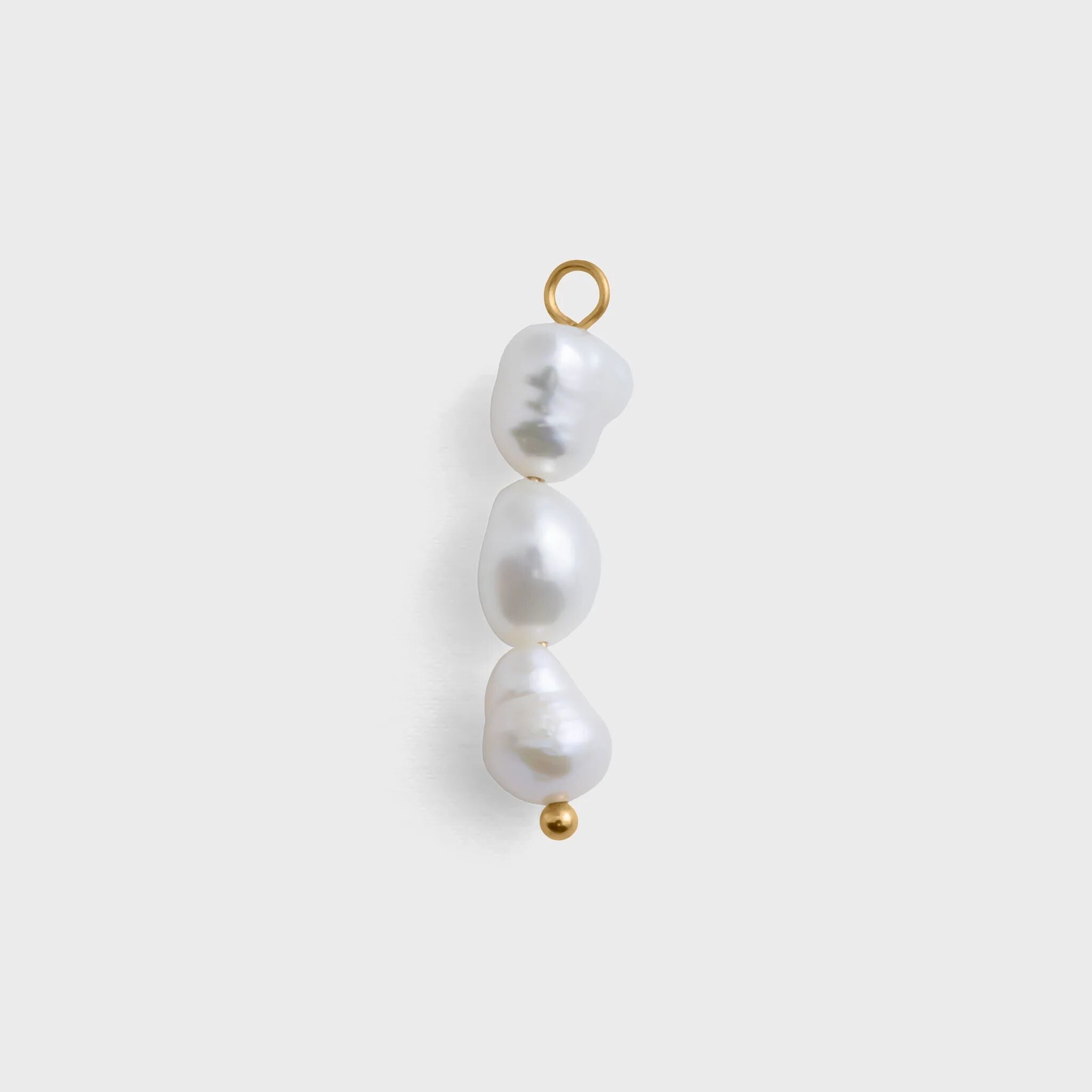 Three pearl beads with gold clasps on a white background