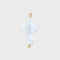 White cross-shaped pendant with gold accents on a light gray background