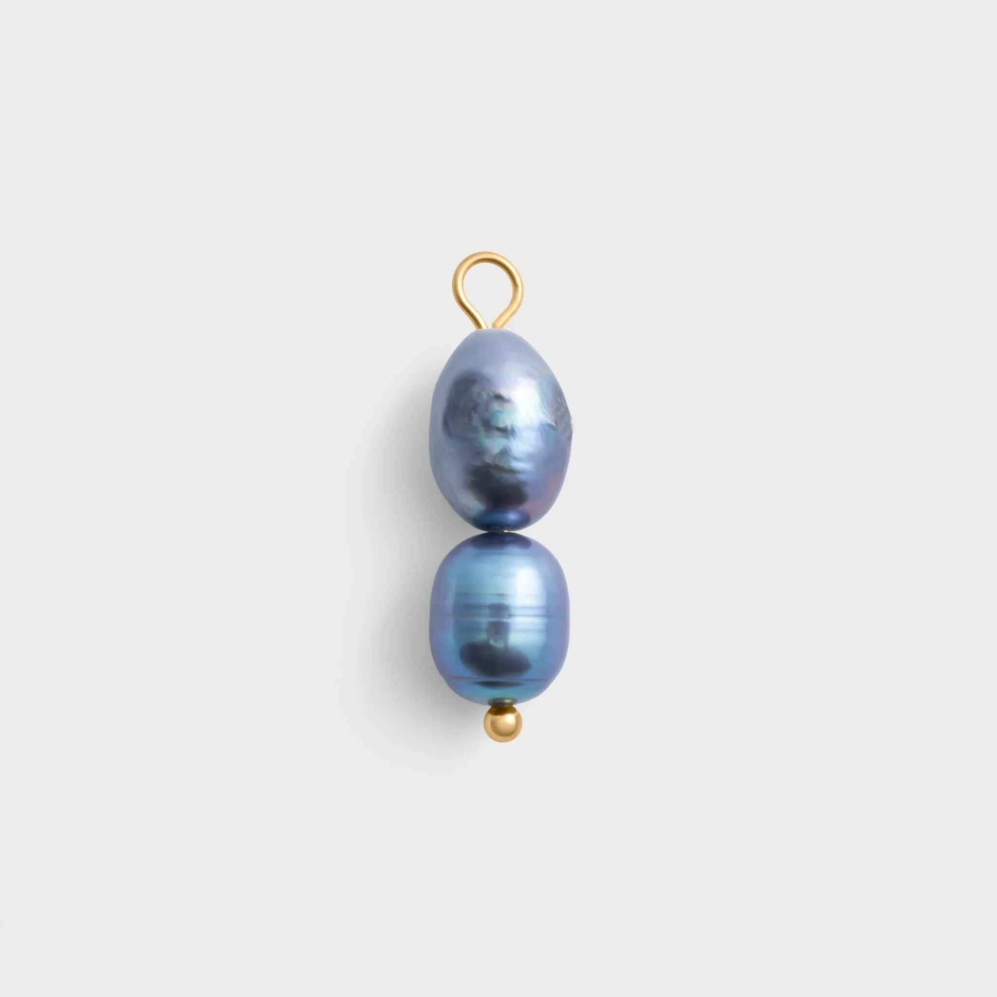 Two black pearls on a gold hook against a light gray background