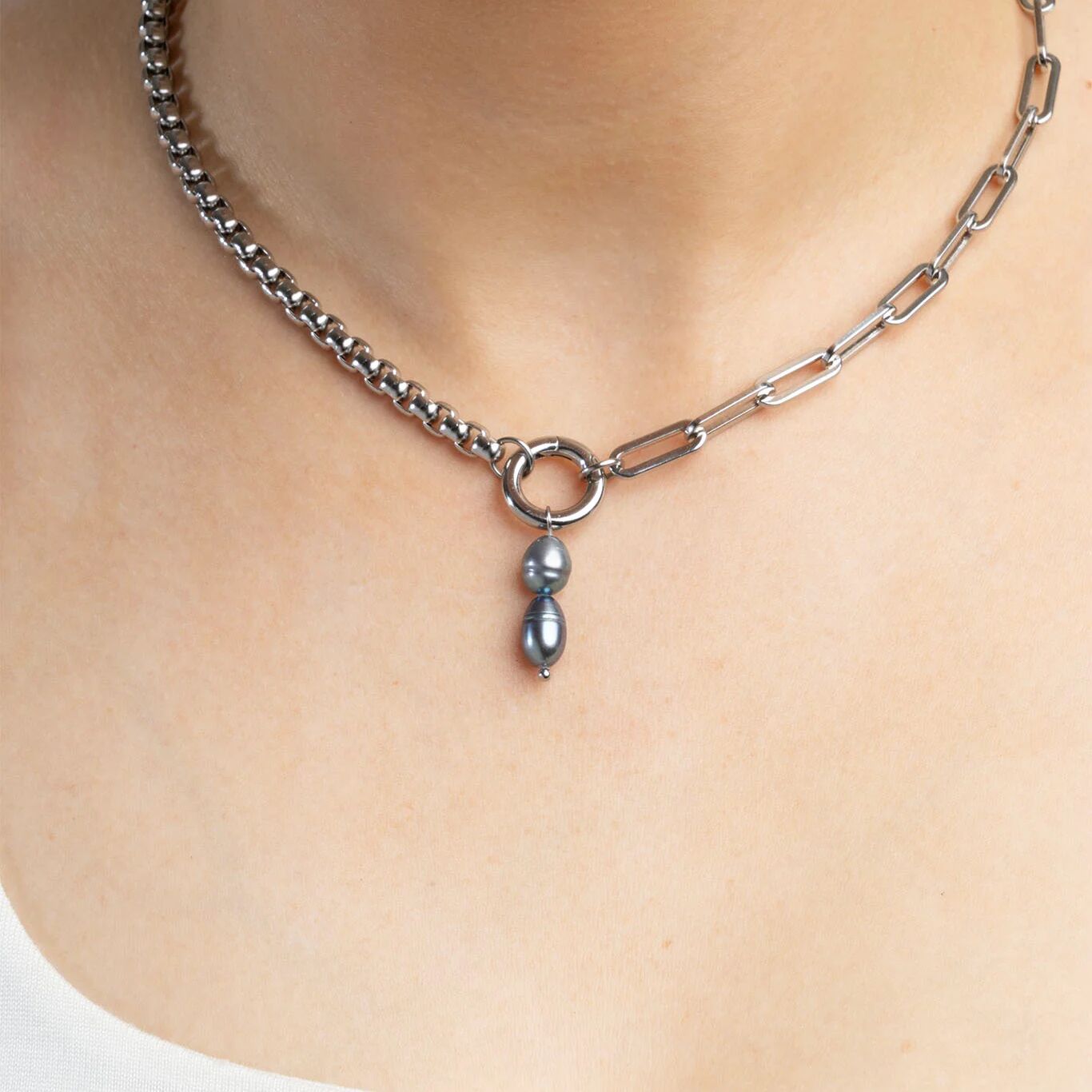 Necklace with a pendant on a person's neck against a neutral background