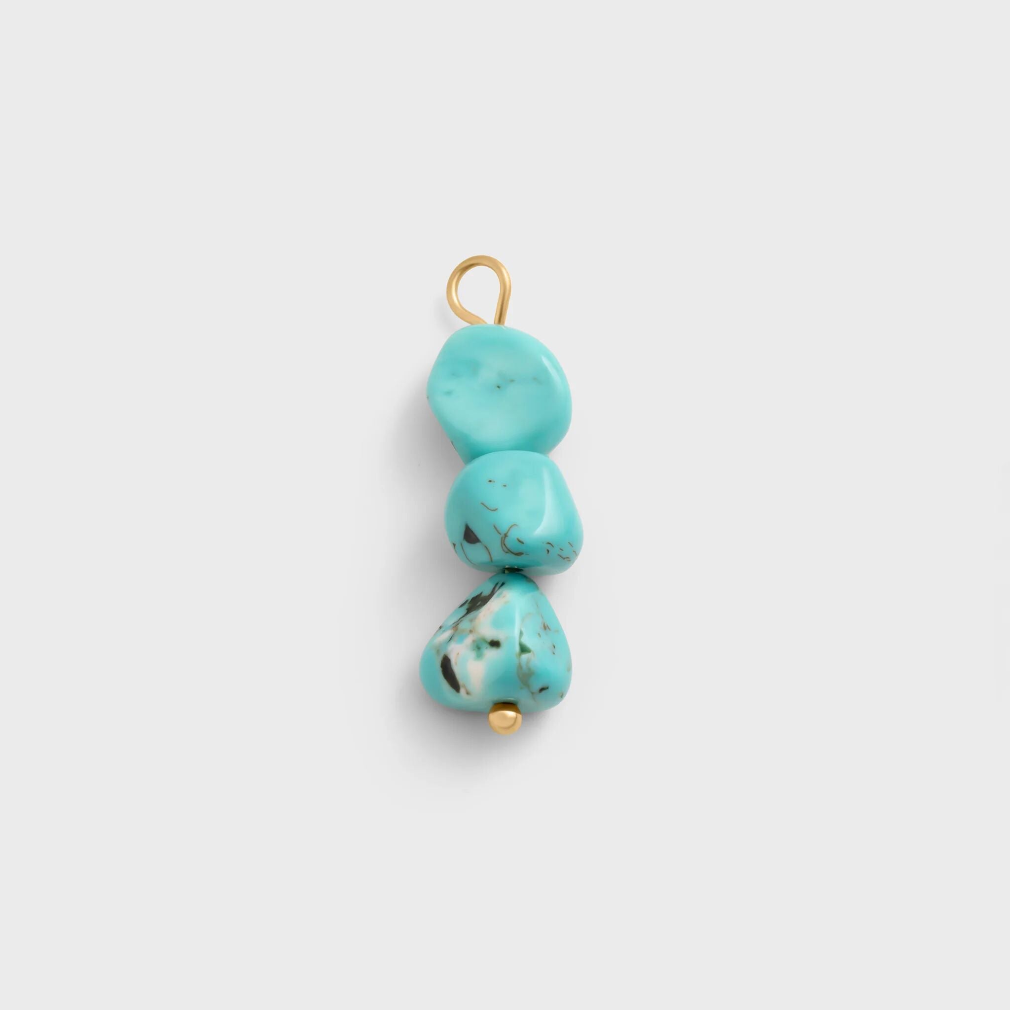 Turquoise stone pendant with gold accents on a light gray background