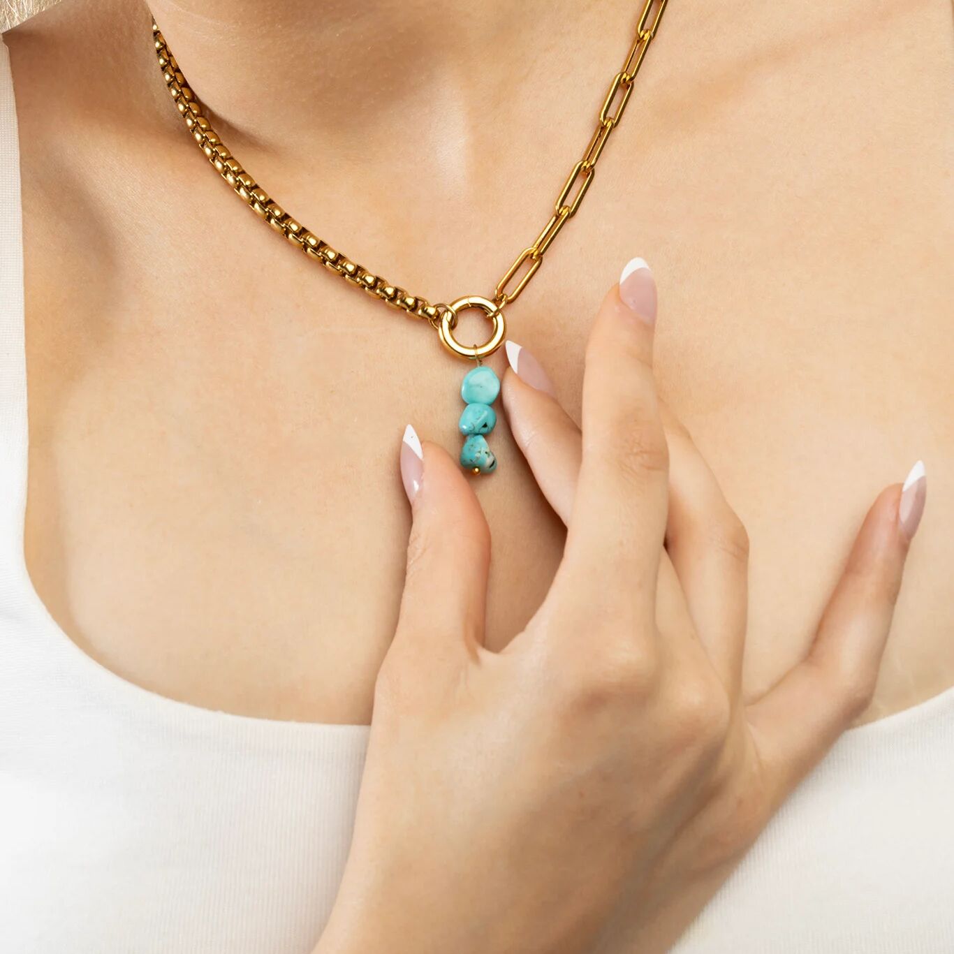 Gold necklace with turquoise beads worn by a person