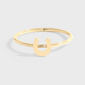 A gold-colored horseshoe ring on a white background