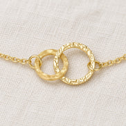 Amity Circle Bracelet — construction detail on ivory fabric; AI-generated supporting image.