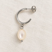 Elara Silver Pearl Drops — construction detail on ivory fabric; AI-generated supporting image.