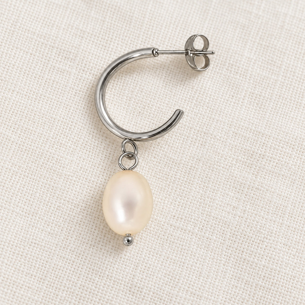 Elara Silver Pearl Drops — construction detail on ivory fabric; AI-generated supporting image.