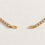 Rhea Link Bracelet — ends detail, gold with clear round stones; AI-generated supporting image.
