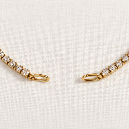 Rhea Link Bracelet — ends detail, gold with clear round stones; AI-generated supporting image.