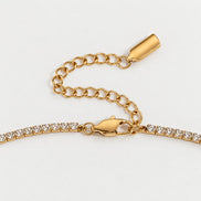 Rhea Link Necklace — clasp detail, gold with clear round stones; AI-generated supporting image.