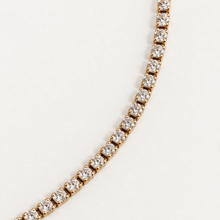 Rhea Link Necklace — stones detail, gold with clear round stones; AI-generated supporting image.