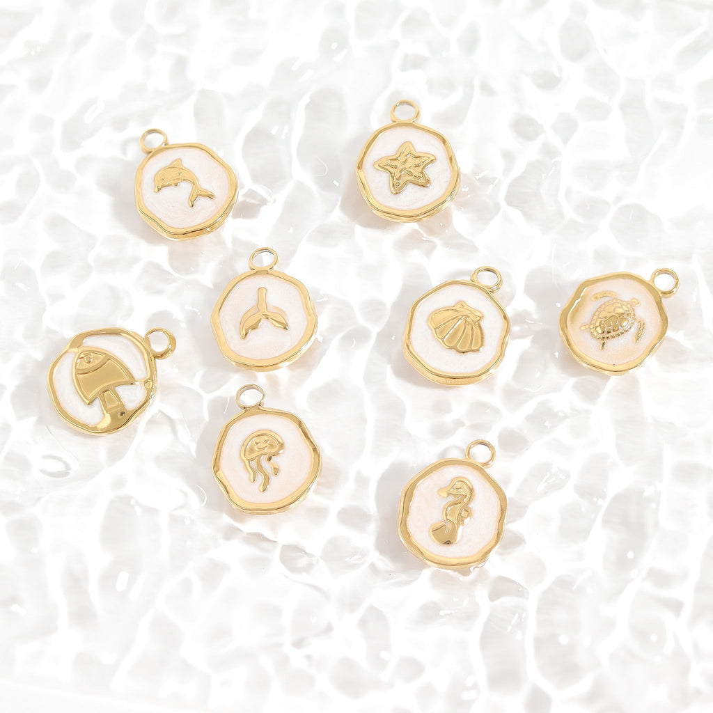 Gold charms with various designs on a white textured background