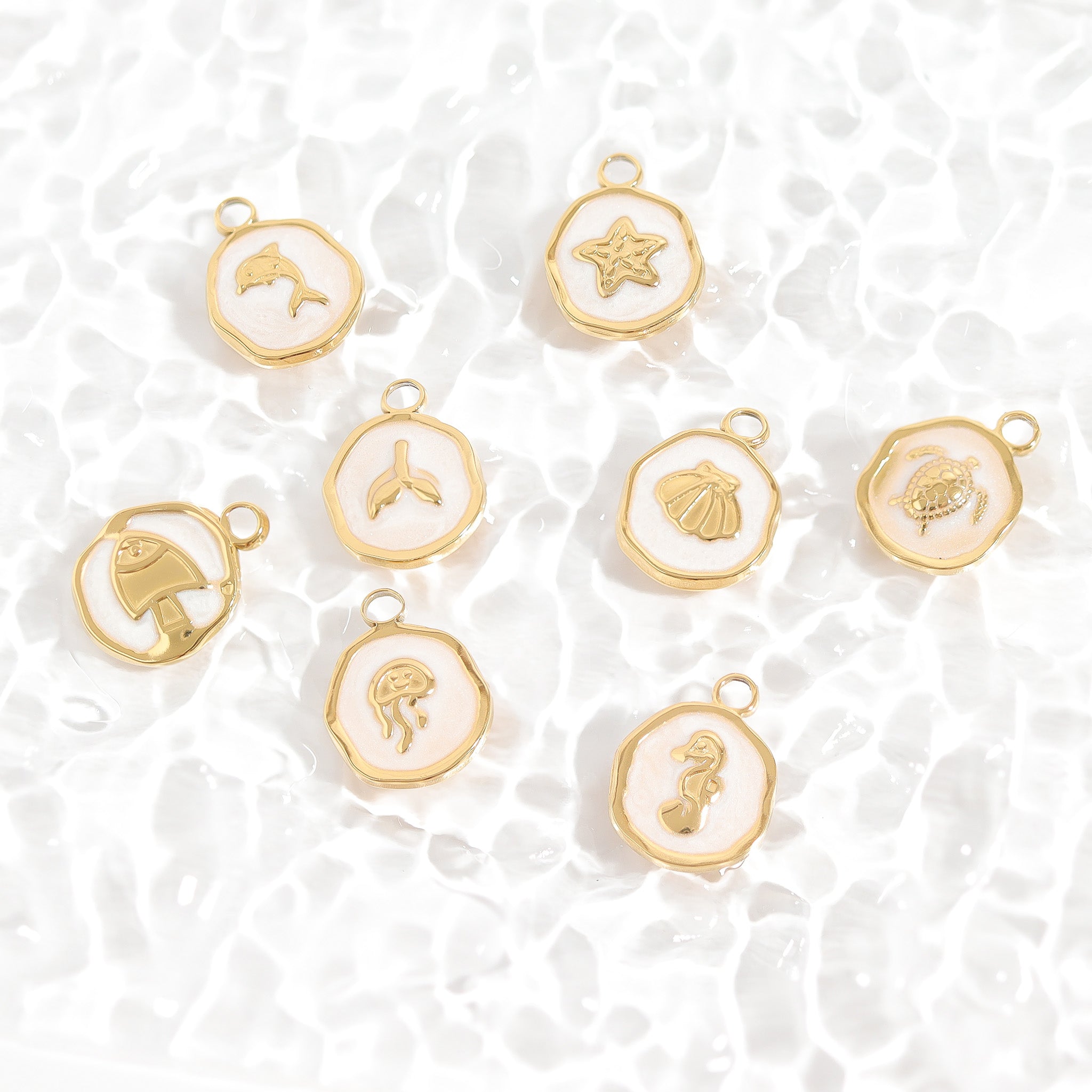 Gold charms with various designs on a white textured background