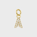 A gold-colored charm in the shape of the letter 'A' adorned with cubic zirconia stones.